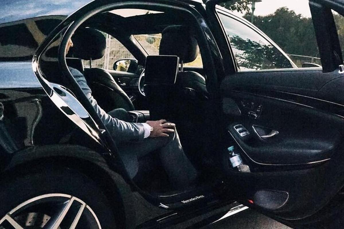 een persoon die op de bestuurdersstoel van een auto zit