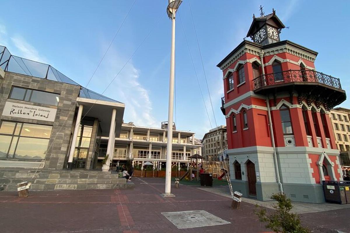 un edificio rosso con una torre dell'orologio di fronte a un edificio