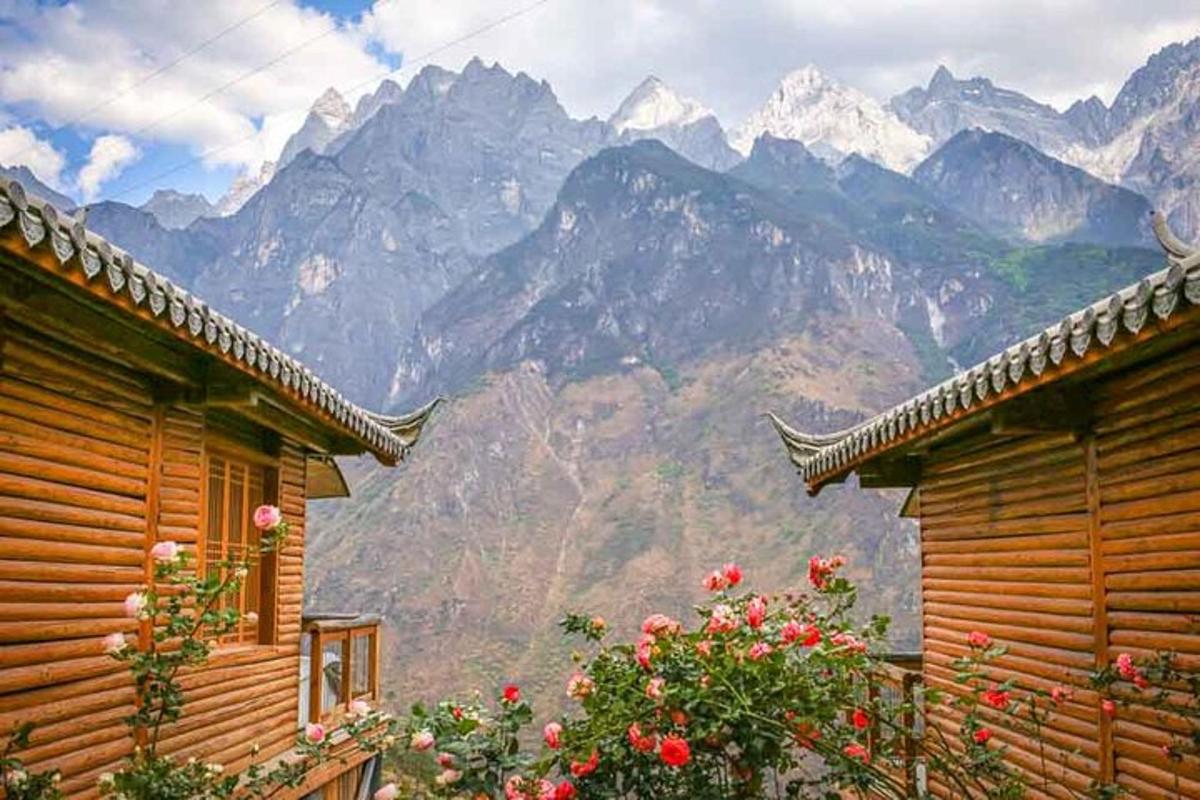 a view of a mountain range with two wooden buildings