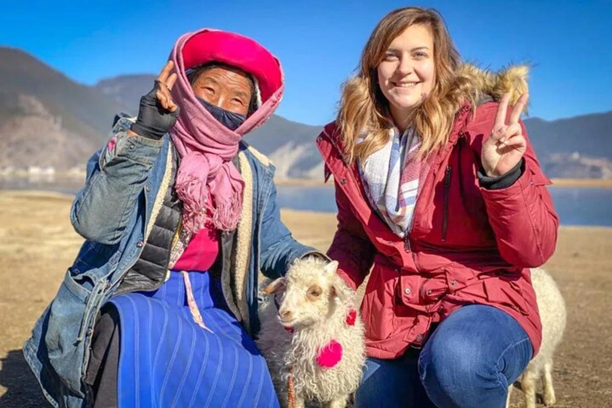 two people posing for a picture with a sheep