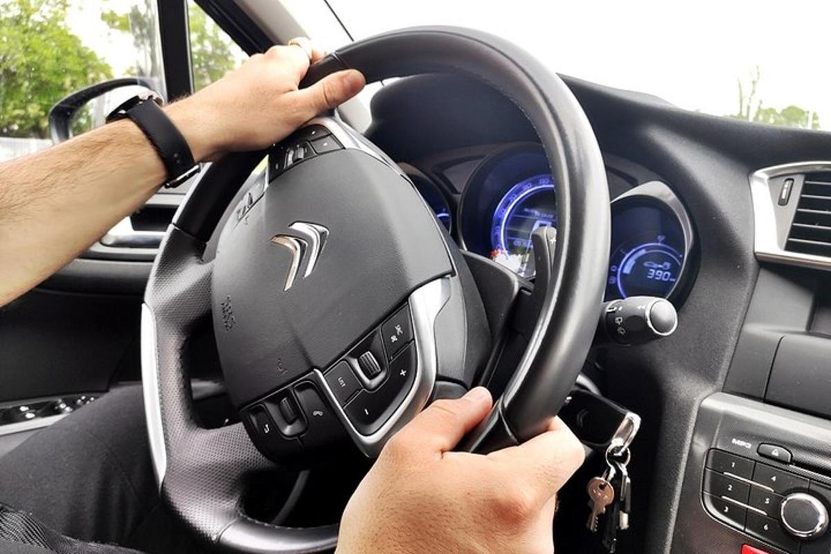 a person holding a steering wheel in a car
