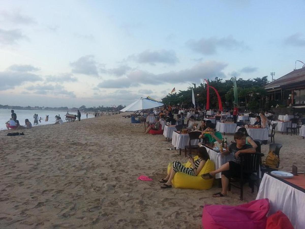 một nhóm người đang ngồi ở bàn trên bãi biển