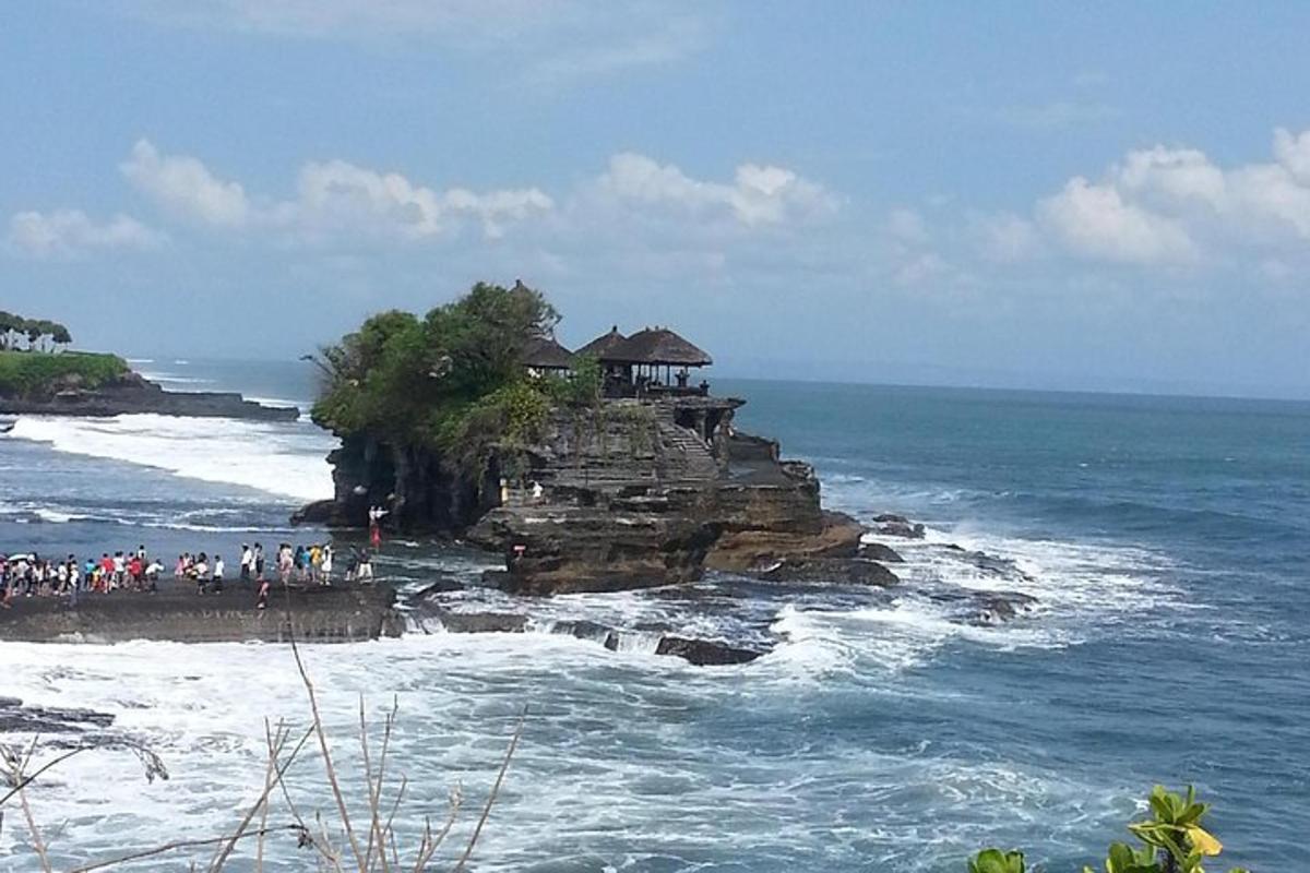 um grupo de pessoas em pé em uma ilha no oceano