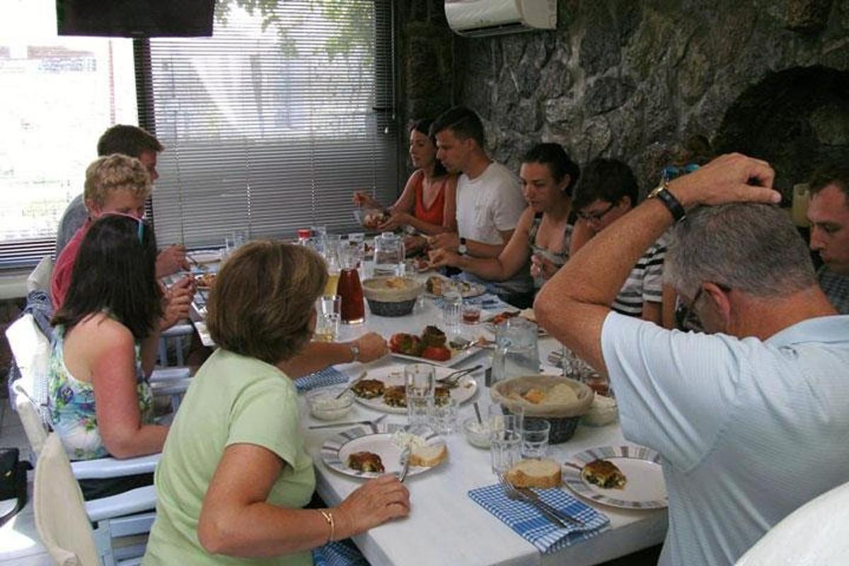 un grup de oameni care stau la o masă și mănâncă