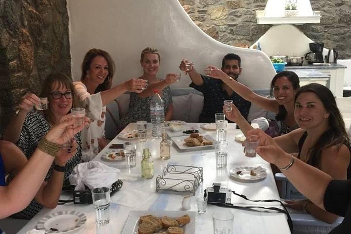 un grup de oameni așezați în jurul unei mese, bând vin