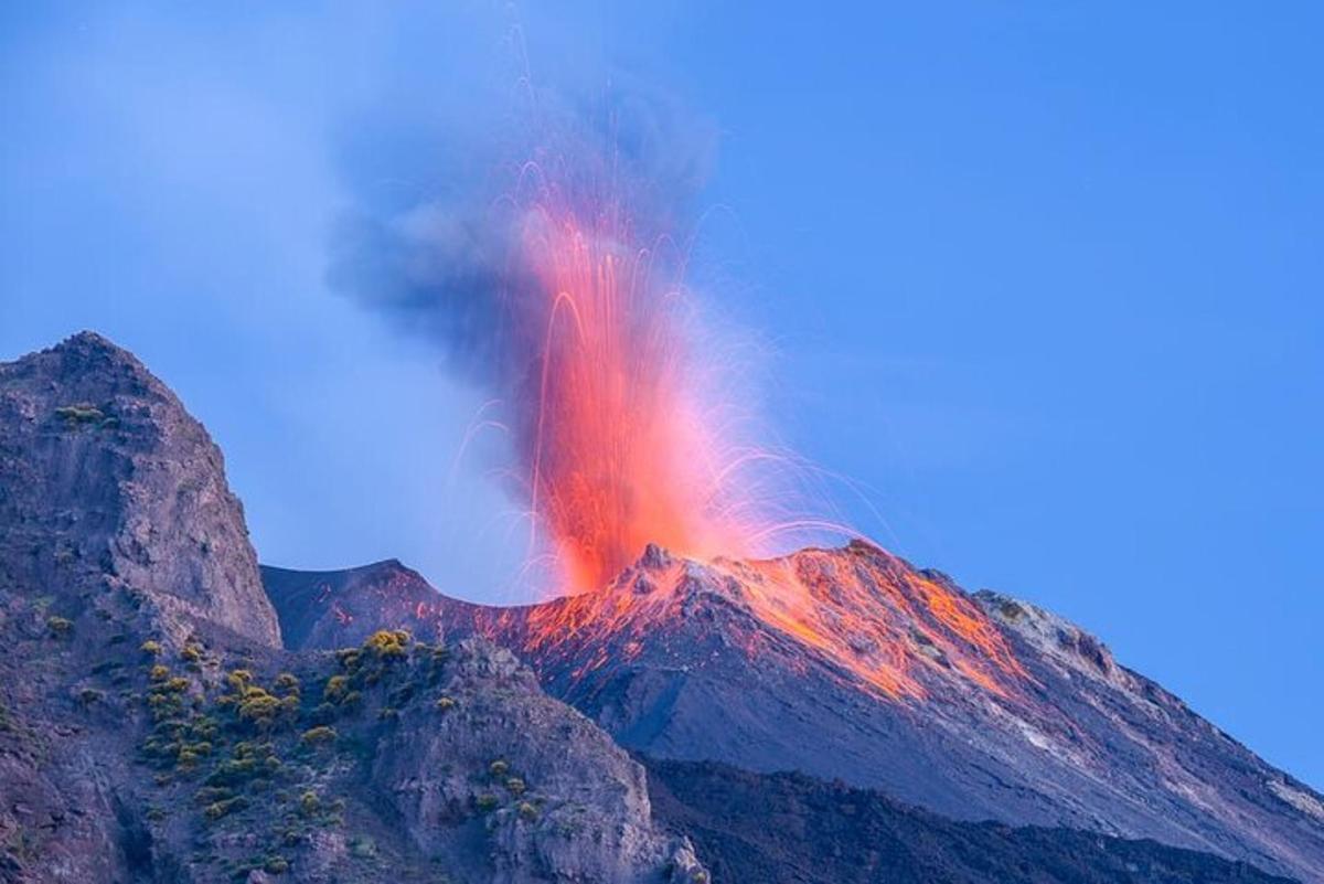 uma montanha com um campo de lava vermelha no topo