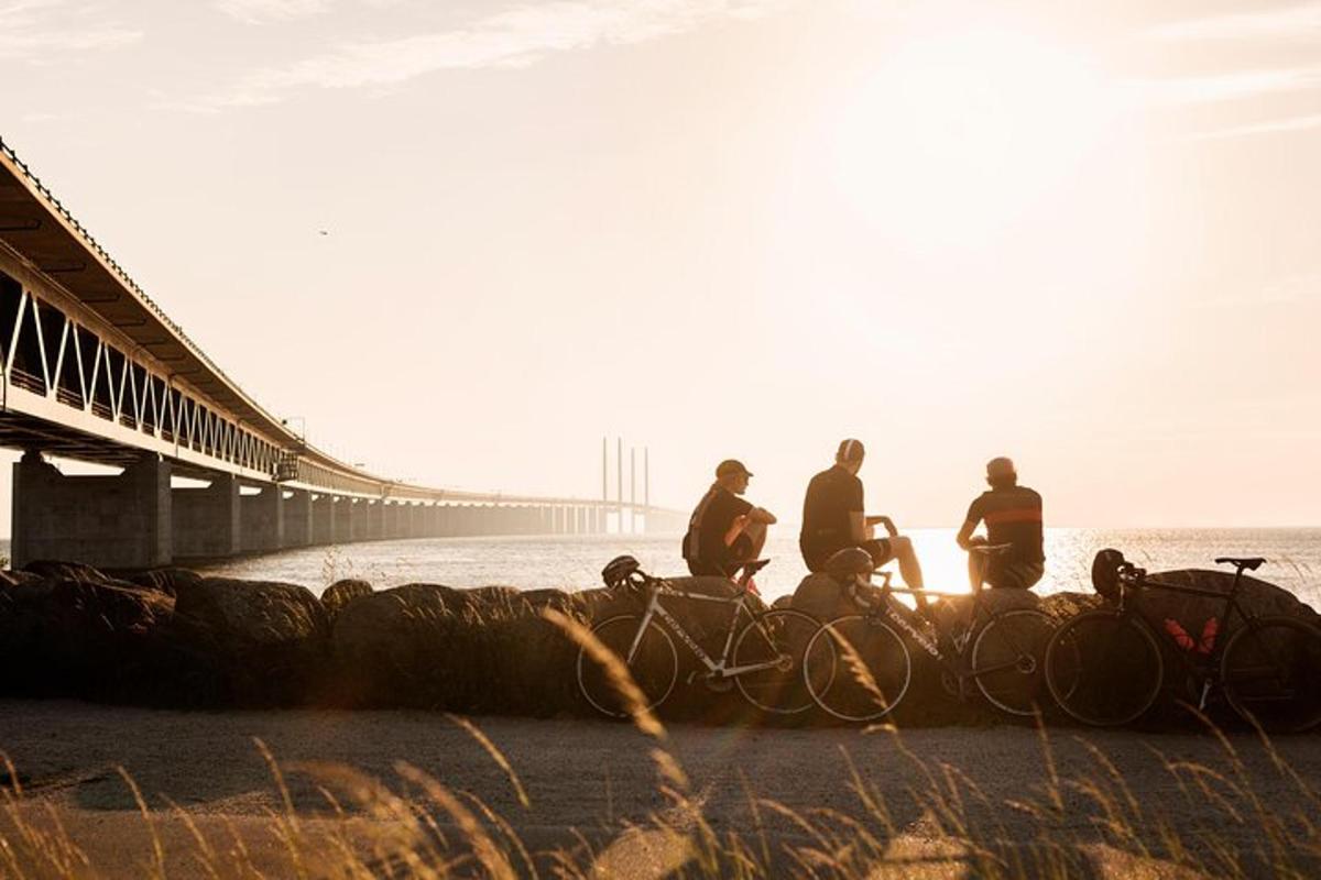 um grupo de pessoas andando de bicicleta perto de uma ponte
