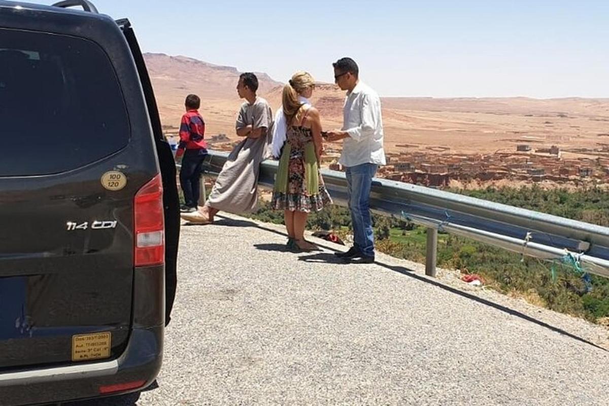 un gruppo di persone in piedi su una strada accanto a un'auto