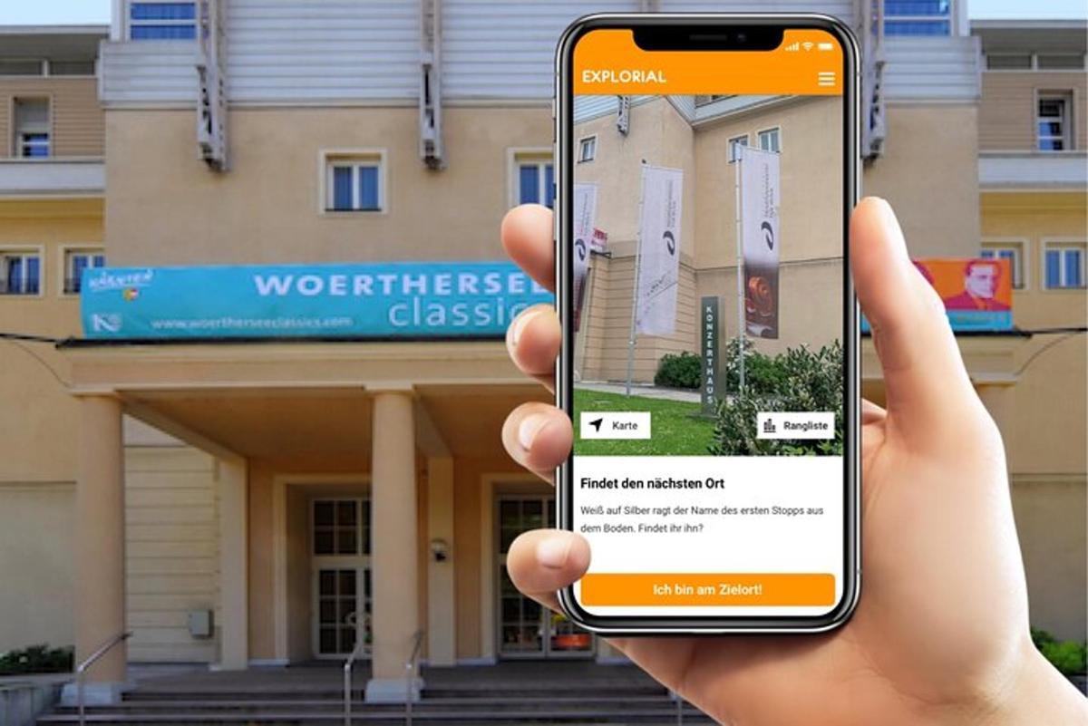 a person holding up a cell phone in front of a building