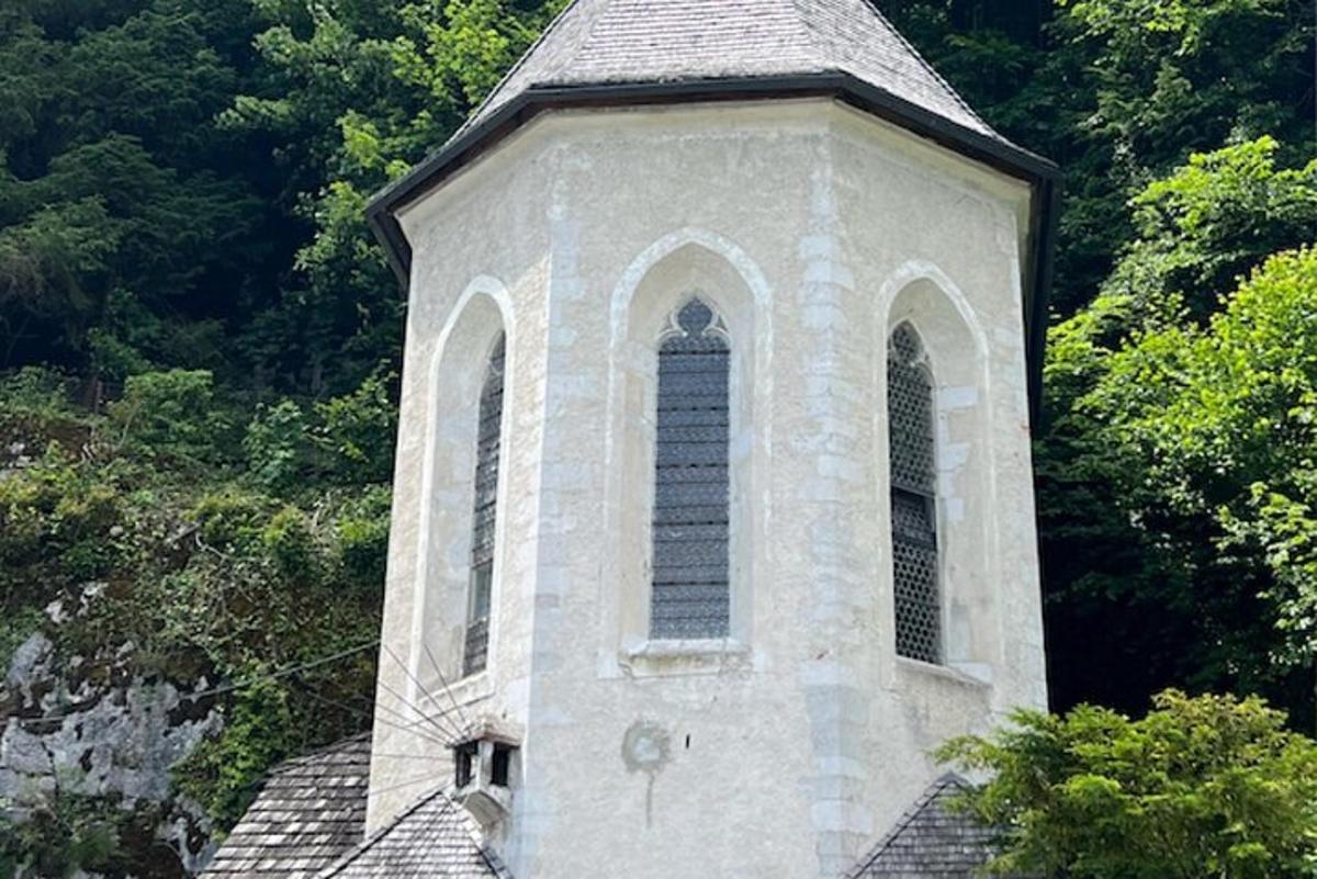 una torre d'església amb una finestra i arbres