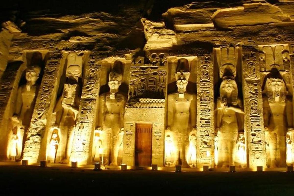 un antico edificio con statue sopra di esso di notte