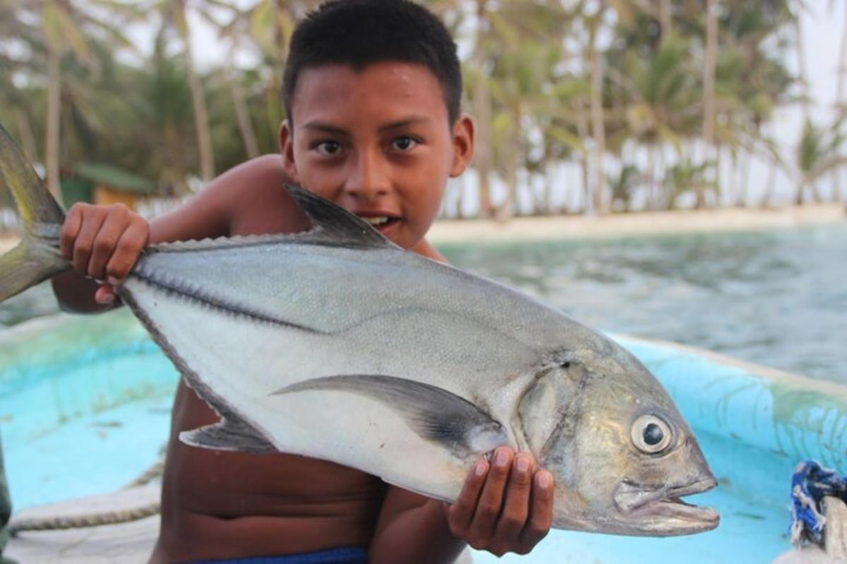 um menino segurando um peixe grande nas mãos