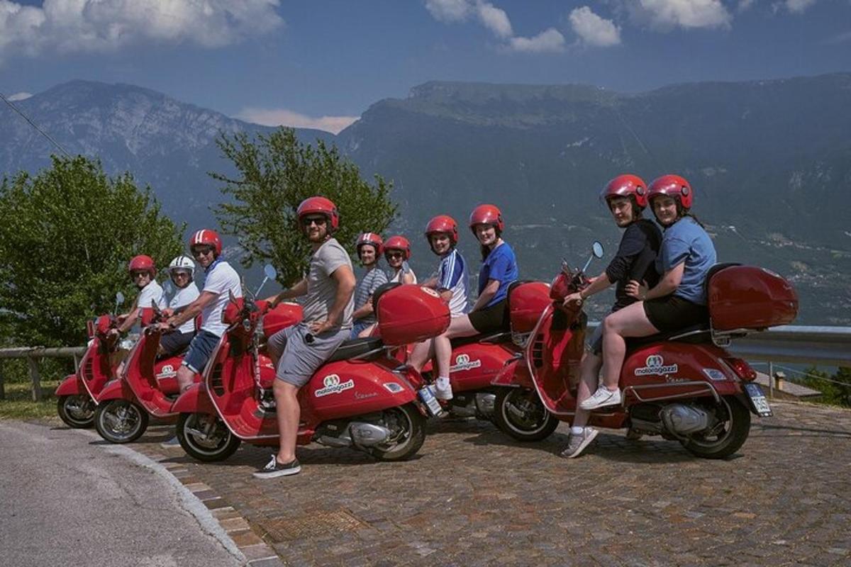 un gruppo di persone sedute su scooter rossi