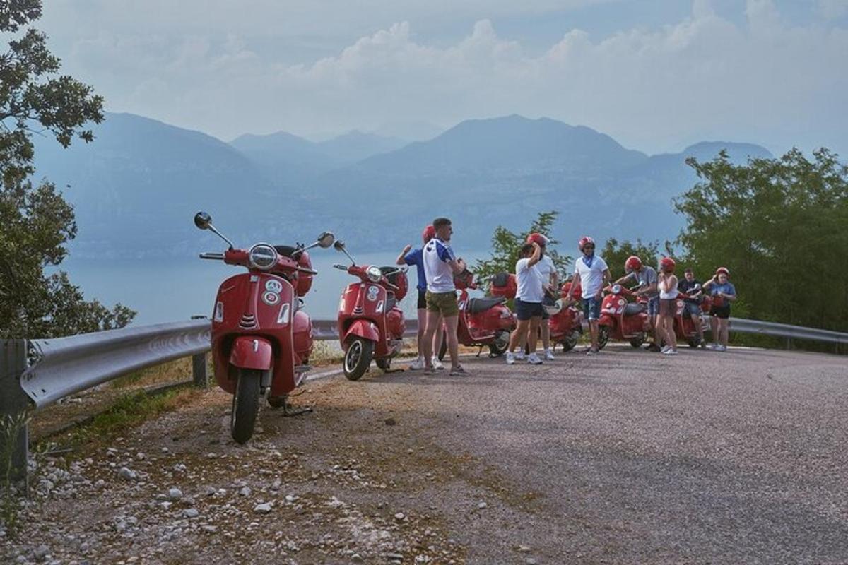 un gruppo di persone in piedi accanto a motociclette su una strada