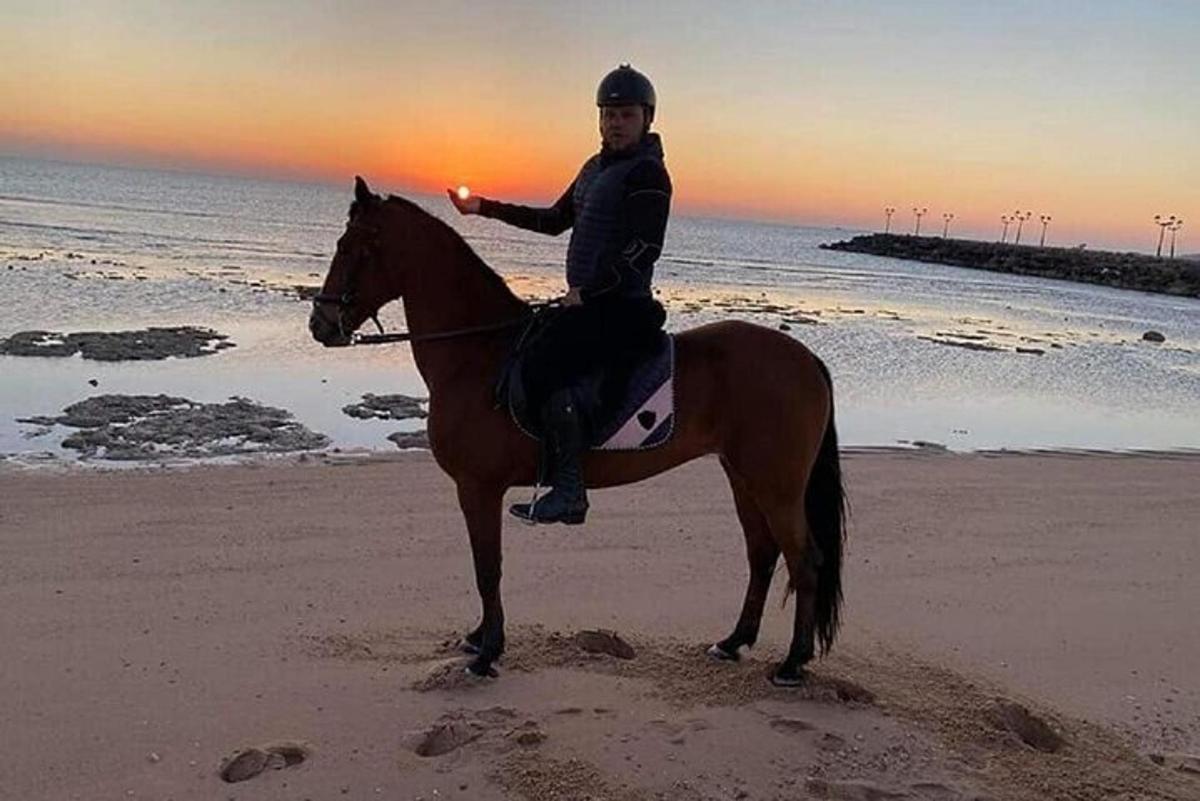 moški, ki jaha konja na plaži