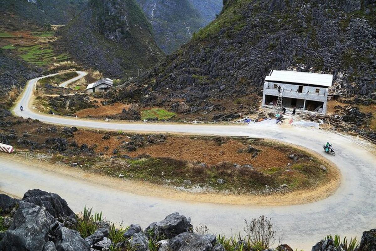 a winding road with a building on the side of a mountain