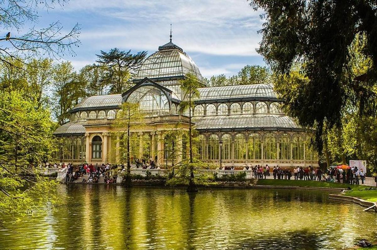 un grande edificio di vetro con uno stagno di fronte
