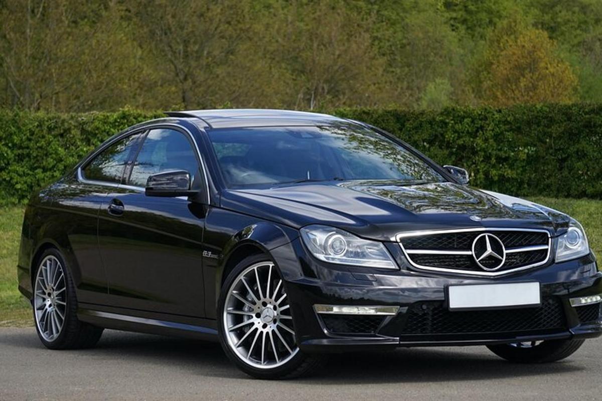 um carro Mercedes Benz preto estacionado em uma estrada