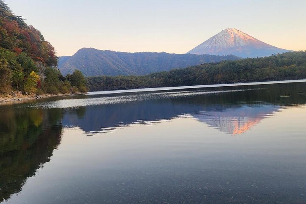 un riflesso di montagna in un lago con una montagna sullo sfondo