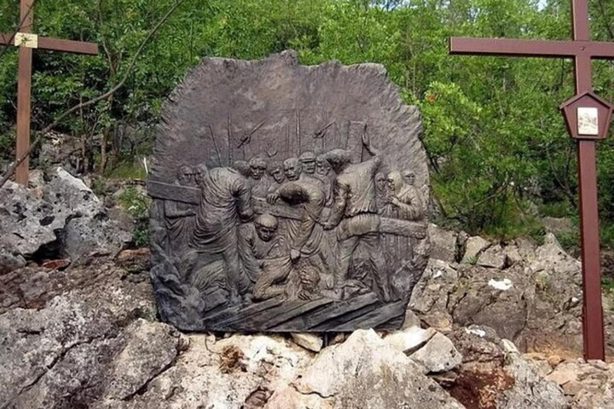 patung sekumpulan manusia di atas batu