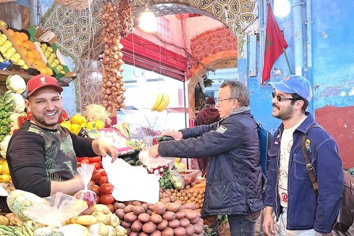 a group of men standing around a market with fruits and vegetables