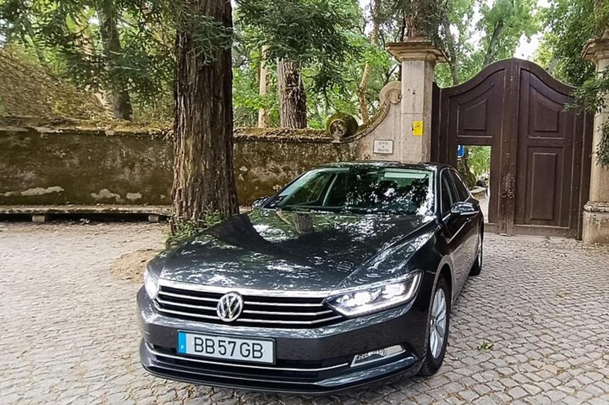 un'auto nera parcheggiata davanti a un albero