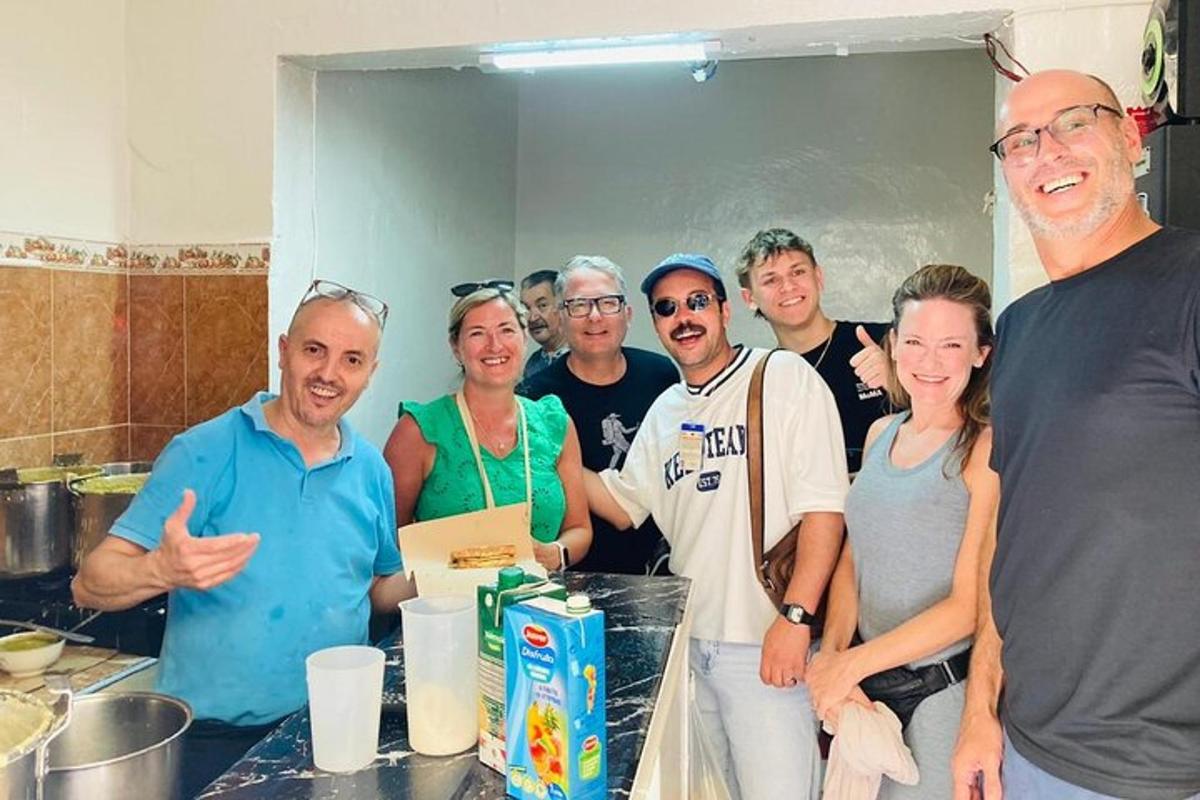 a group of people posing for a picture in a kitchen