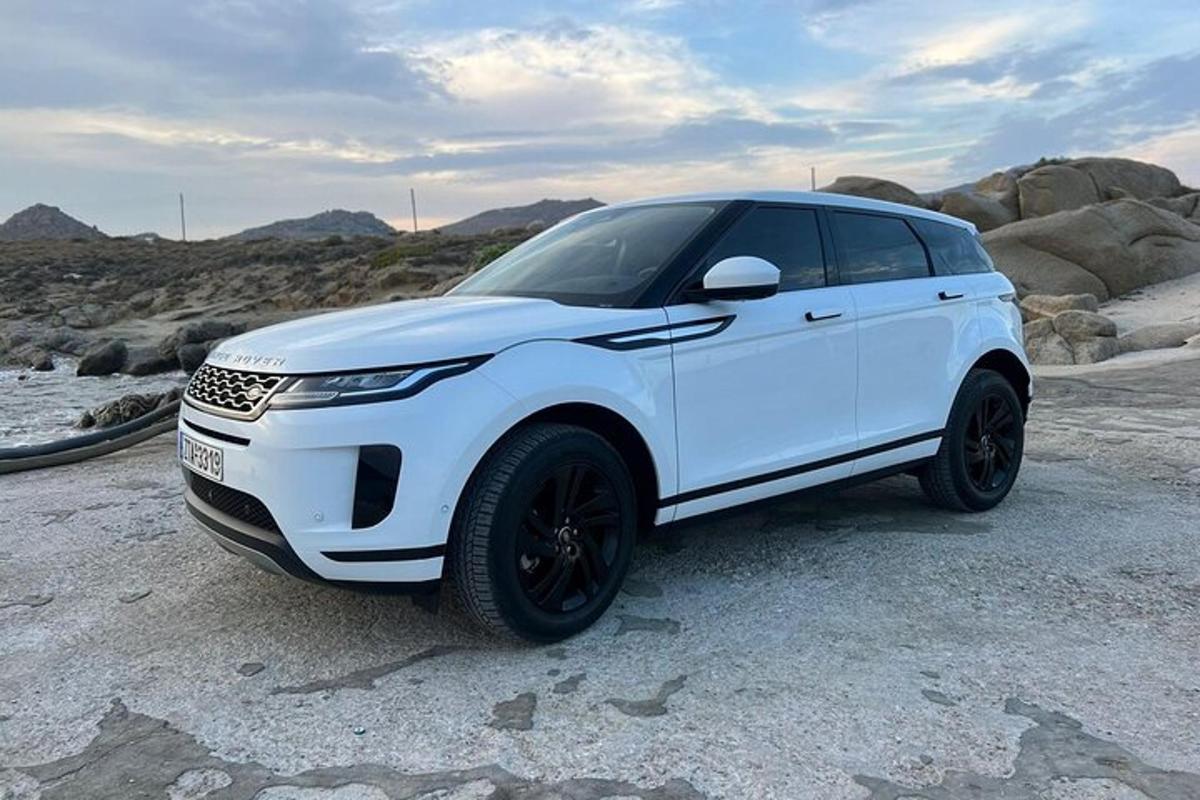 una camioneta blanca estacionada en una playa rocosa