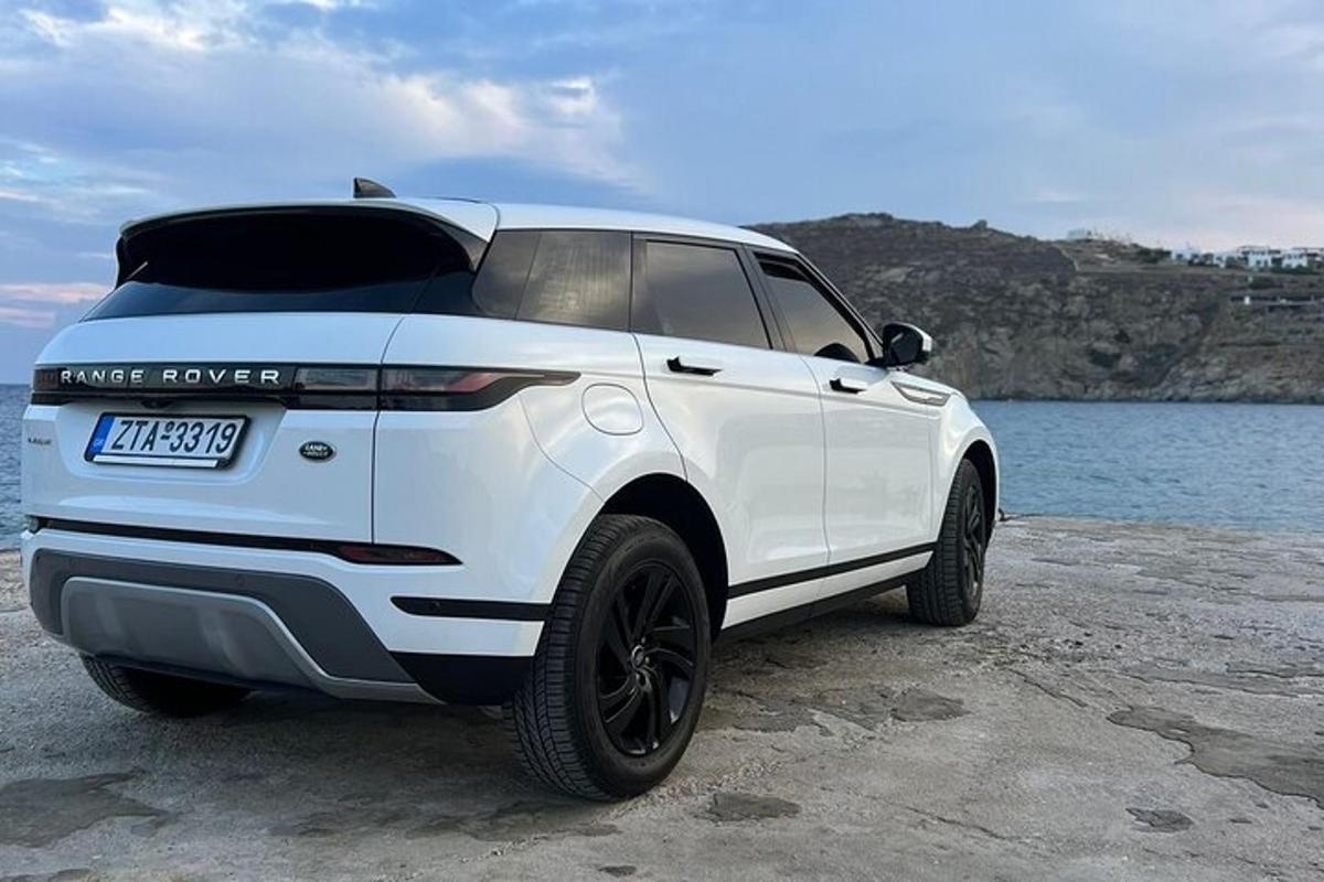Una camioneta blanca estacionada junto a un cuerpo de agua