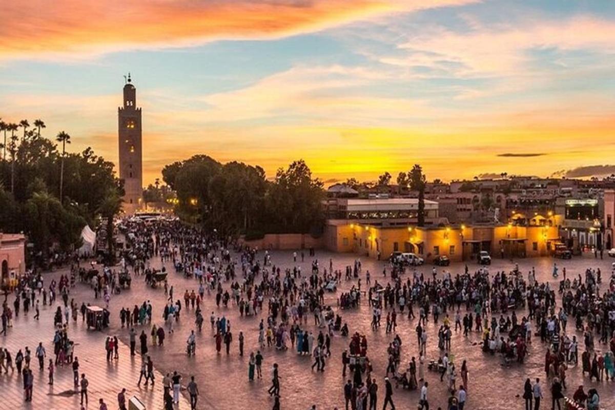 velká skupina lidí stojící na náměstí při západu slunce