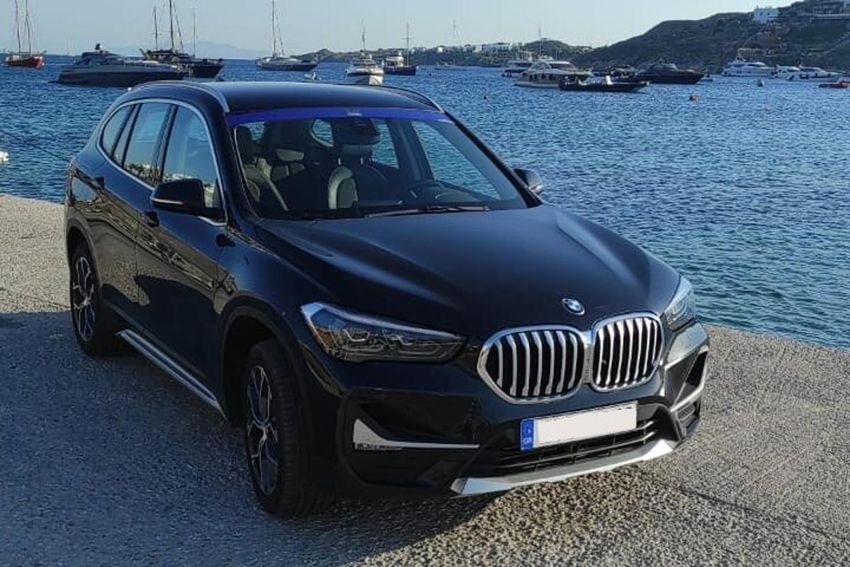 a black car parked next to a body of water