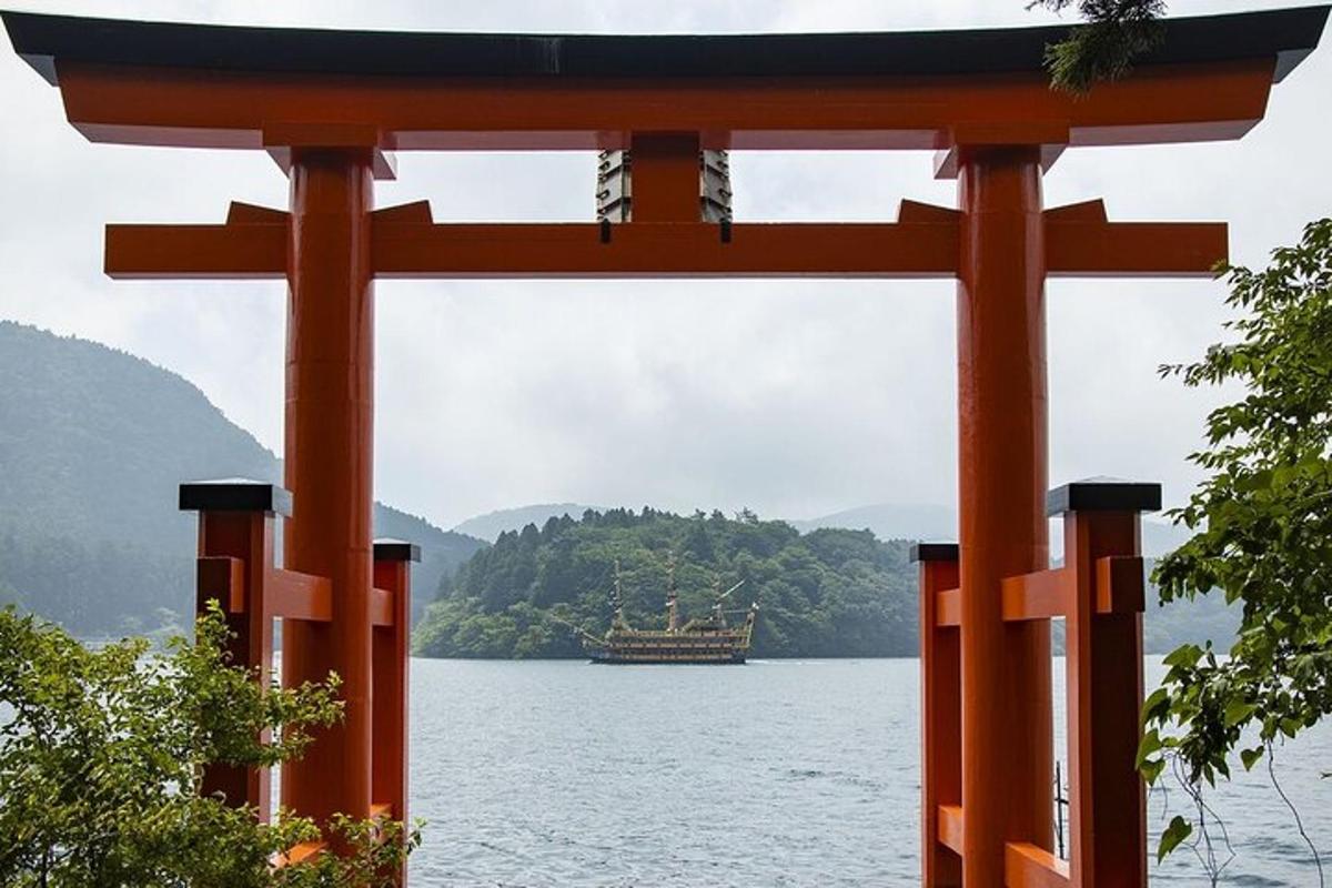 an orange torii gate with a boat in the water