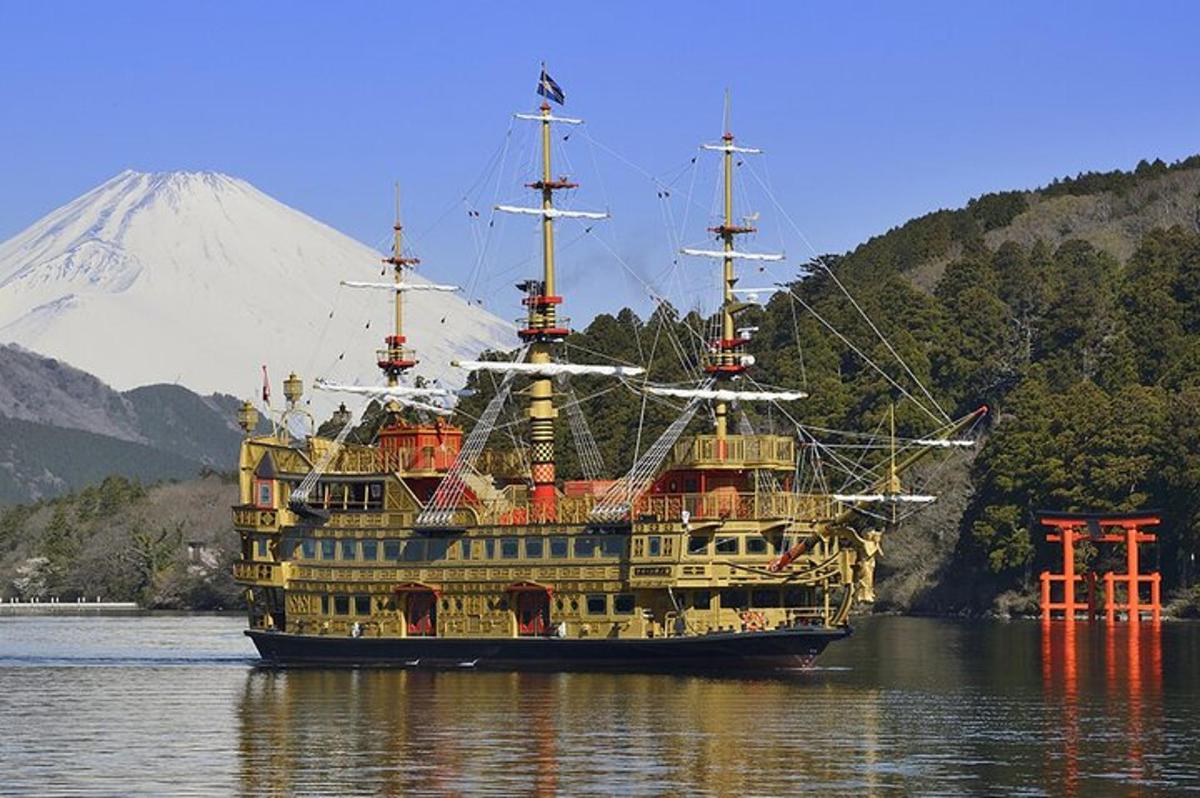una grande barca in acqua con una montagna sullo sfondo