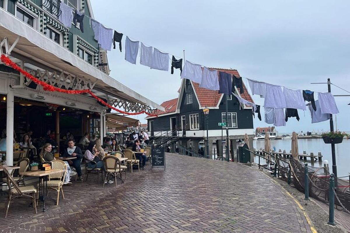 een groep mensen die aan tafels op straat zitten met waslijnen