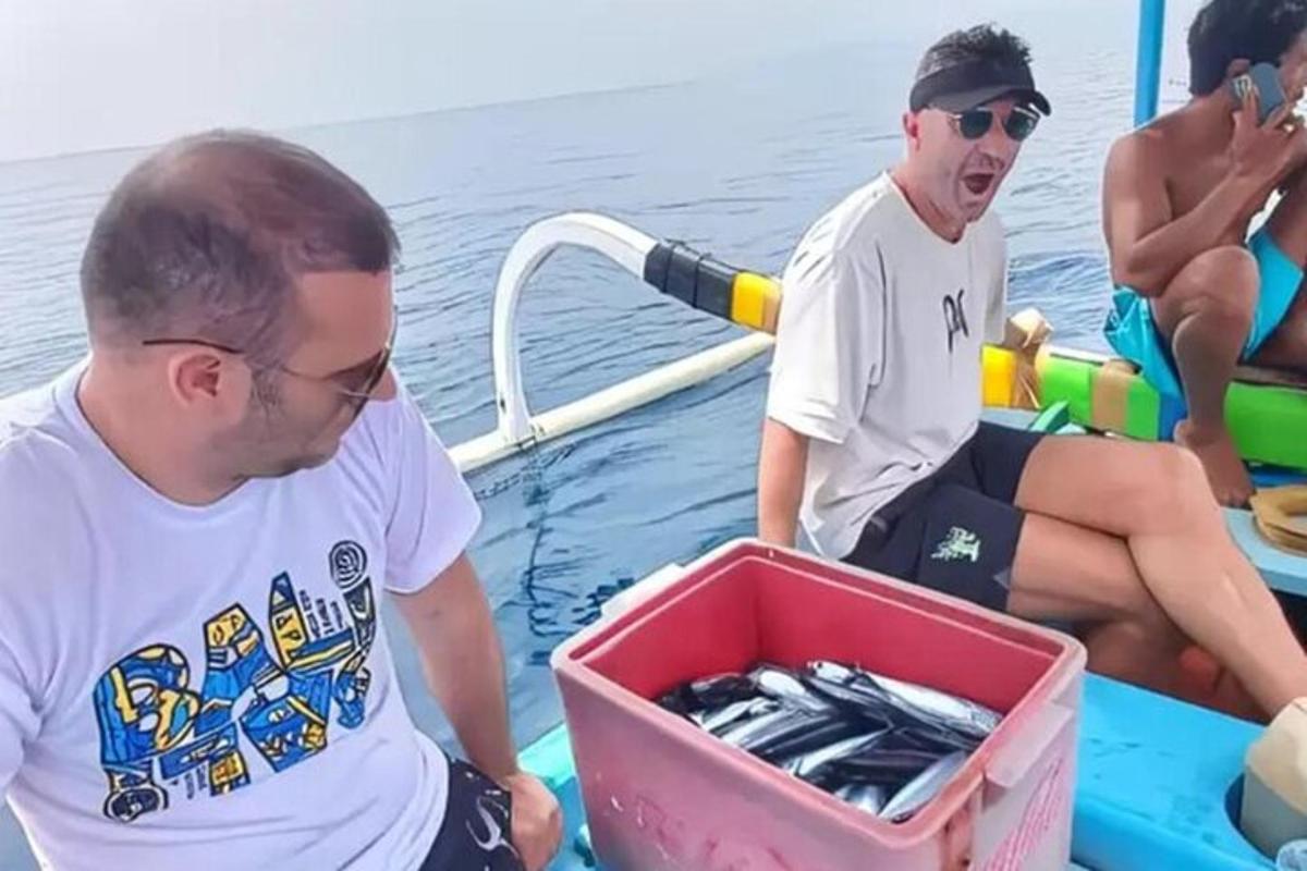 due uomini su una barca con una scatola di pesce