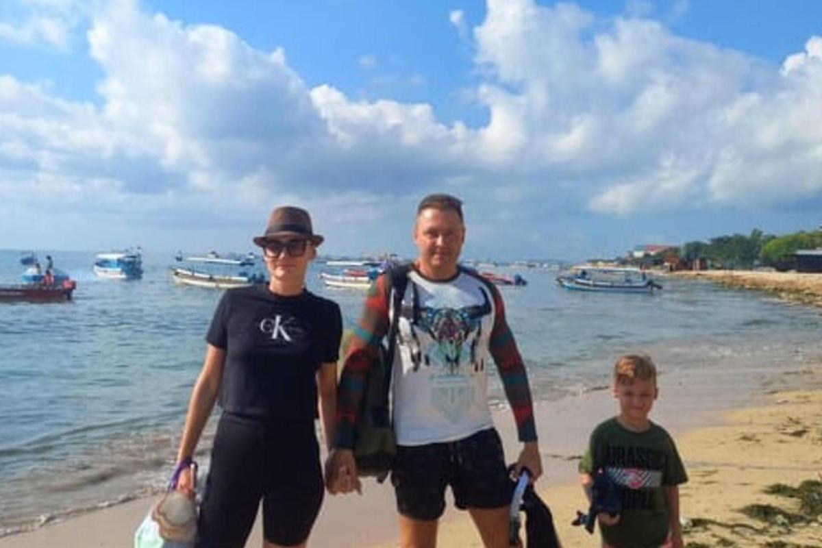 un uomo e due ragazzi in piedi sulla spiaggia