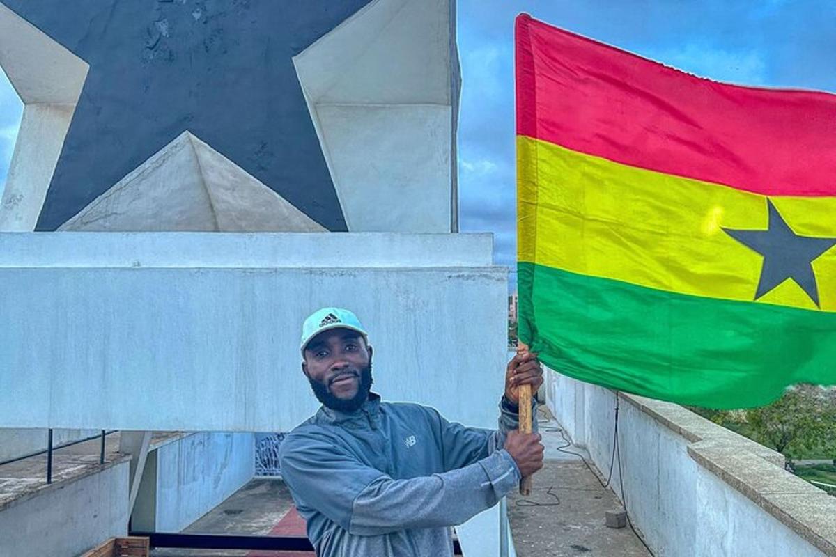 a man holding a flag in front of a building