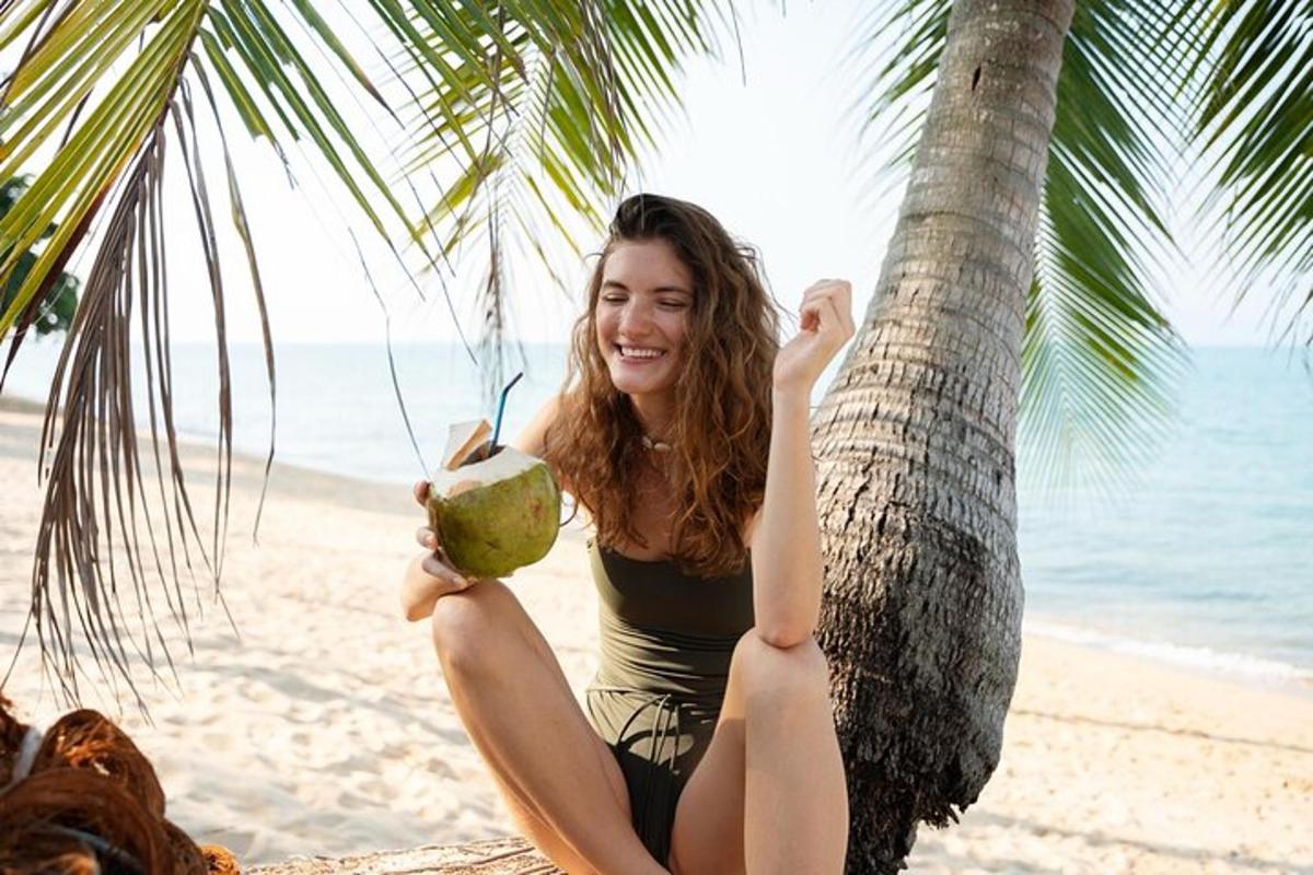 Una niña sentada en una palmera sosteniendo un coco.