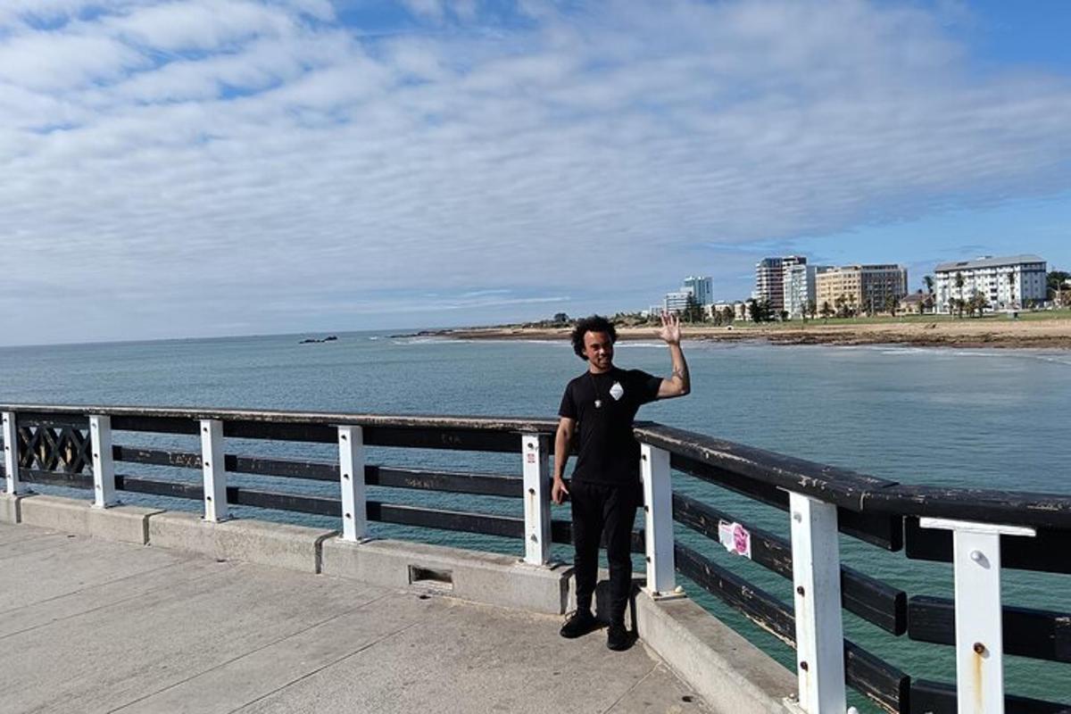 a man standing on a pier next to the ocean