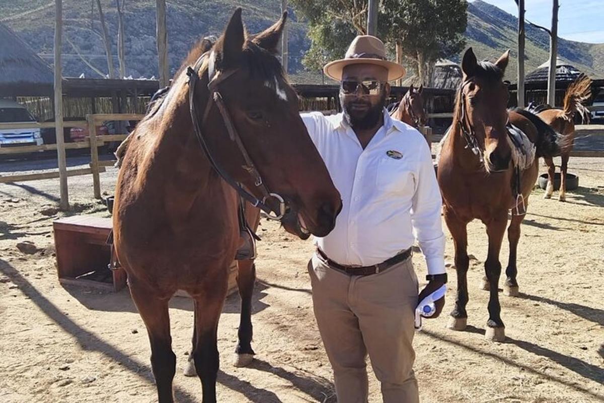 un home amb un barret de cowboy dret al costat d'un cavall