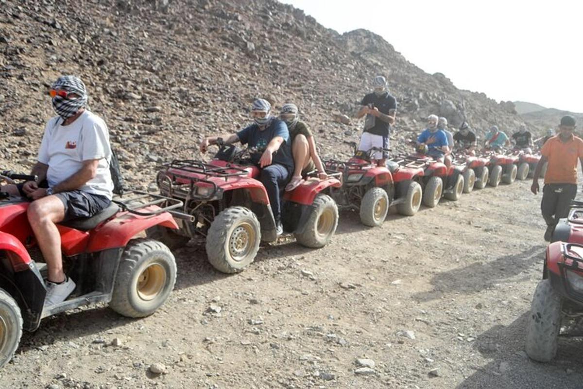 um grupo de pessoas descendo uma montanha em quadriciclos