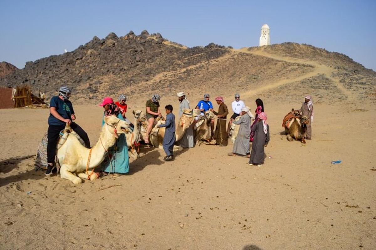 um grupo de pessoas andando de camelo no deserto