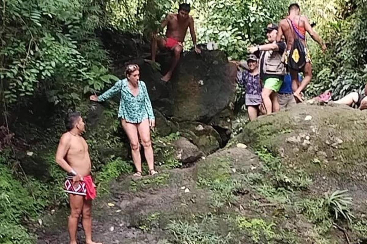 sekumpulan orang berdiri di atas batu di dalam hutan