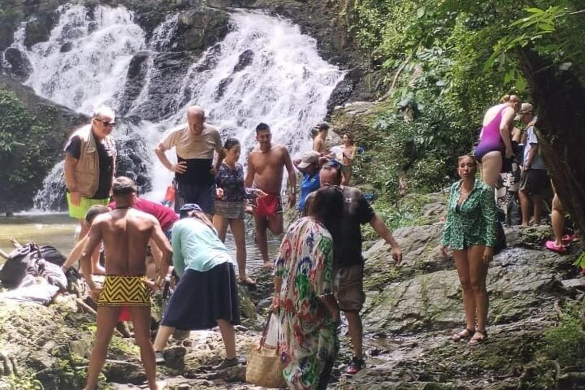 un groupe de personnes debout devant une cascade