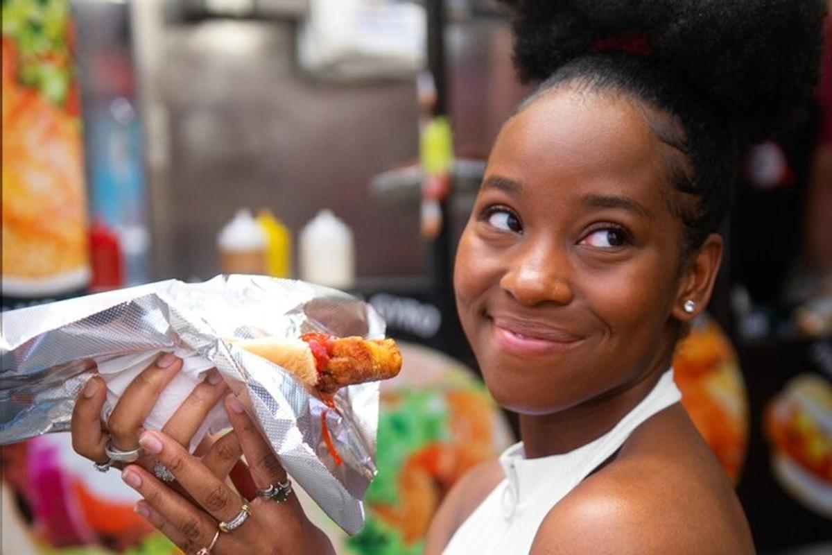 o femeie care ține un hot dog într-o folie
