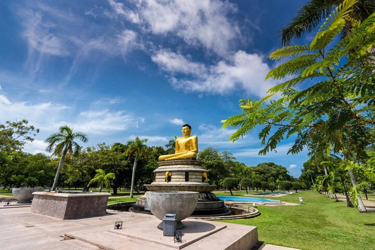 a golden statue in a park with palm trees