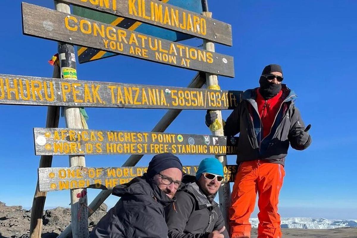 un gruppo di tre uomini in piedi accanto a un cartello