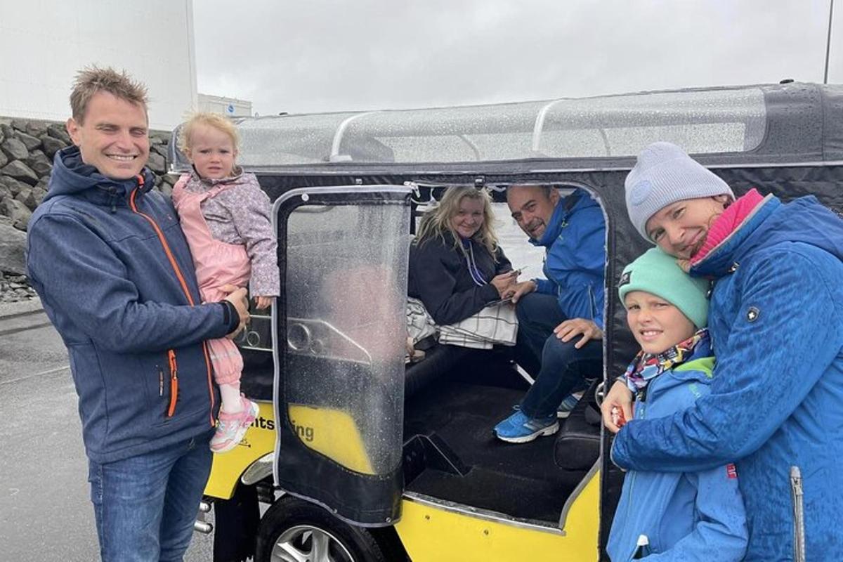egy csoport ember áll egy golfkocsi mellett