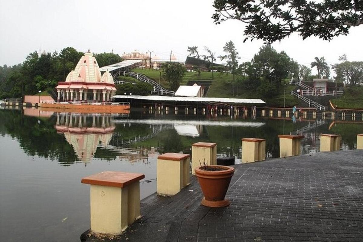 a pond with a gazebo and a building in the water