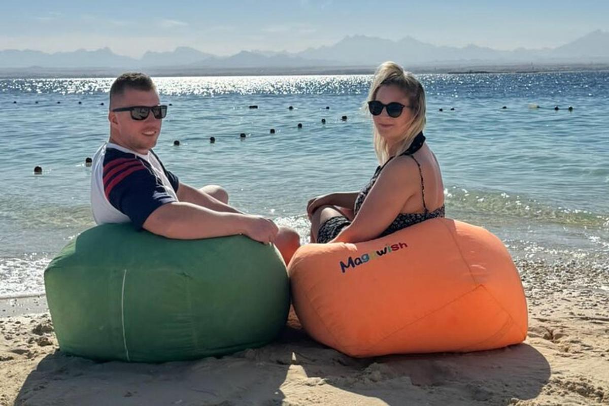 Maður og kona sitja á uppblásnum leiktækjum á ströndinni